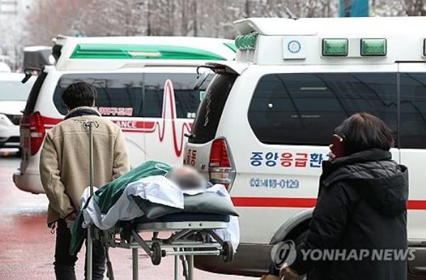 A patient is moved to an ambulance in front of a medical clinic in Seoul to be transferred to another one on Feb. 2, 2024, amid trainee doctors' walkout in protest of the government's plan to raise the medical school enrollment quota. (Yonhap)