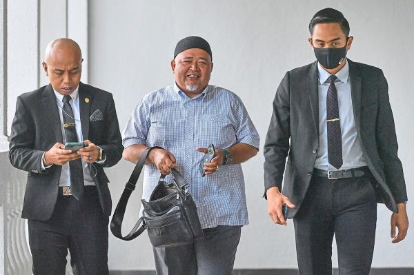 Day in court: Mohamad Hilmi (centre) arriving at the court building in Kuala Lumpur. — Bernama