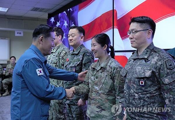 Defense Minister Shin Won-sik (L) shakes hands with a U.S. service member during his visit to the Command Post Tango bunker complex in Seongnam, just south of Seoul, on March 13, 2024, in this photo provided by his office. (PHOTO NOT FOR SALE) (Yonhap)