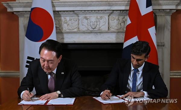 This file photo, taken Nov. 23, 2023, shows President Yoon Suk Yeol (L) and British Prime Minister Rishi Sunak signing the 