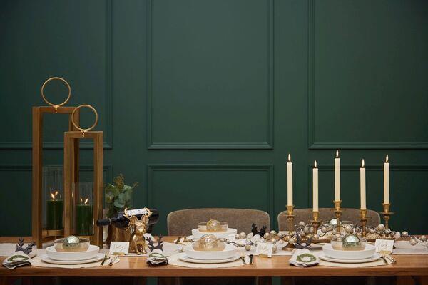  Adding height to the Christmas dining table with a candelabra (candle tray holder 59) and hurricane lamps (Thorpe from 89) from Meadows & Byrne gives a wow finish.